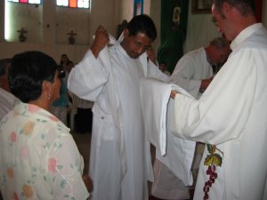 El Padre Antonio Muraro reviste al Padre Enrique con la estola y la casulla.
