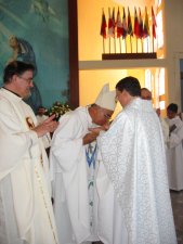 El Señor Obispo besa las manos recién unguidas del Padre Manuel.